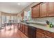 Modern kitchen featuring wooden cabinets, granite countertops, and stainless steel dishwasher at 134 Paces Lakes Overlook, Dallas, GA 30157
