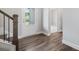 Bright foyer showcasing wood-look floors, staircase with dark wood trim, and entrance door with glass, creating an inviting space at 306 Bunker Hill Ct, Acworth, GA 30102