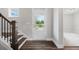 Bright foyer featuring elegant wood floors, staircase with dark wood trim, and a view to other rooms at 306 Bunker Hill Ct, Acworth, GA 30102