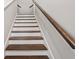 Staircase with dark wood treads, white risers, and a wooden handrail at 306 Bunker Hill Ct, Acworth, GA 30102