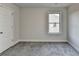Neutral bedroom features gray carpet, a window providing ample natural light, and a white door at 3328 Sir Gregory Mnr, Lawrenceville, GA 30044