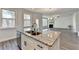 Bright kitchen with granite island and stainless steel dishwasher flowing to living area at 3328 Sir Gregory Mnr, Lawrenceville, GA 30044