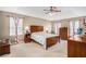 Spacious main bedroom featuring a tray ceiling, ceiling fan and carpeted floors at 83 Southshore Ln, Dallas, GA 30157