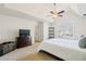 Bright main bedroom with a tray ceiling, ceiling fan, and a large window overlooking the front yard at 33 Grand Ave, Suwanee, GA 30024