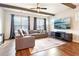 Bright living room with hardwood floors, ceiling fan, decorative beams, and leather sofa at 2435 Folly Se Ln, Atlanta, GA 30339