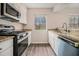 Well-lit kitchen with stainless steel appliances, granite countertops, and white cabinetry at 3875 Mcgill Way, Decatur, GA 30034