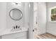 Modern powder room with round mirror, vanity and window at 648 Liella Se Park, Atlanta, GA 30312