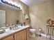 Bathroom with neutral patterned walls, light cabinets and a white sink at 7440 Princeton Trce, Sandy Springs, GA 30328