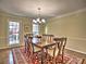 Elegant dining room with a large wooden table, chandelier, and a view to the front yard at 7440 Princeton Trce, Sandy Springs, GA 30328