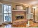 Close-up of the brick fireplace with mantle, complemented by windows and shutters at 7440 Princeton Trce, Sandy Springs, GA 30328