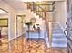 Welcoming foyer with hardwood floors, staircase, and a decorative table with flowers at 7440 Princeton Trce, Sandy Springs, GA 30328