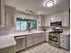 Well-lit kitchen featuring white cabinets, stainless steel appliances, and a view to the backyard at 7440 Princeton Trce, Sandy Springs, GA 30328