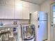 Well-equipped laundry room offering cabinetry, washer, dryer, and exterior door at 7440 Princeton Trce, Sandy Springs, GA 30328