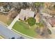 Aerial view of a red brick home featuring a lush lawn, trees, and circular driveway on a cul-de-sac at 340 Ruby Forest Pkwy, Suwanee, GA 30024