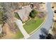 Aerial view of a brick home with well-kept lawn, mature trees, and a circular driveway at 340 Ruby Forest Pkwy, Suwanee, GA 30024