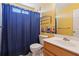 A cozy full bathroom featuring cheerful yellow walls and a blue shower curtain, complemented by a charming vanity at 340 Ruby Forest Pkwy, Suwanee, GA 30024