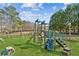 Community playground featuring swings, slides, and climbing structures on lush green grass at 340 Ruby Forest Pkwy, Suwanee, GA 30024