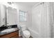 Bright bathroom featuring a shower-tub combo, toilet, and vanity with a dark countertop at 404 Paperbark Ct, Acworth, GA 30102