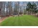 Secluded backyard area with a manicured lawn and wooded backdrop offers serenity at 455 Emerald Lake Path, Sugar Hill, GA 30518