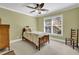 A bedroom with green walls, a ceiling fan and a bright window at 455 Emerald Lake Path, Sugar Hill, GA 30518