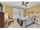 A bedroom with yellow walls, a ceiling fan and a bright window at 455 Emerald Lake Path, Sugar Hill, GA 30518