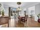 Elegant dining room with wood floors, chandelier, and large windows, seamlessly flowing into the foyer at 455 Emerald Lake Path, Sugar Hill, GA 30518