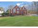 Charming two-story brick home featuring a well-manicured lawn, complemented by mature trees and beautiful landscaping at 455 Emerald Lake Path, Sugar Hill, GA 30518