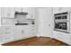 Bright kitchen features white cabinets, herringbone backsplash, and stainless steel appliances at 455 Emerald Lake Path, Sugar Hill, GA 30518