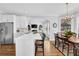 Kitchen featuring stainless appliances, white cabinetry, hardwood floors, and an island with seating at 455 Emerald Lake Path, Sugar Hill, GA 30518