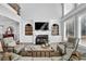 Sun-lit living room featuring a cozy fireplace, built-in shelving, and large windows at 455 Emerald Lake Path, Sugar Hill, GA 30518