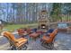 Entertain in this outdoor kitchen with a stone fireplace, built-in grill, and comfortable seating area at 455 Emerald Lake Path, Sugar Hill, GA 30518