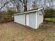 This is an external view of the detached garage, featuring light blue siding and a roll-up door at 6518 Voyles Dr, Riverdale, GA 30274