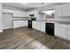 A modern kitchen featuring white cabinets, black appliances, granite countertops, and hardwood flooring at 6518 Voyles Dr, Riverdale, GA 30274