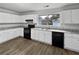 This is a modern kitchen featuring white cabinets, black appliances, granite countertops, and hardwood flooring at 6518 Voyles Dr, Riverdale, GA 30274