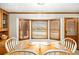 Cozy dining area featuring a bay window with natural light and a wooden dining table set for four at 345 Wedgefield Dr, Mcdonough, GA 30252