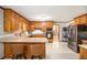 Spacious kitchen with stainless steel appliances, wooden cabinets, breakfast bar, and light tile flooring at 345 Wedgefield Dr, Mcdonough, GA 30252