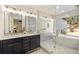 Luxurious bathroom with dual sinks, modern lighting, and a separate shower and bathtub at 4217 Paces Ferry Se Rd, Atlanta, GA 30339