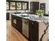 Modern kitchen island with a sink, stainless steel dishwasher, and stone countertops at 4217 Paces Ferry Se Rd, Atlanta, GA 30339