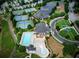 Aerial view showcasing a community with pools, tennis courts, clubhouse, green spaces, and well-maintained landscaping at 1411 Wisteria Wall Dr, Suwanee, GA 30024