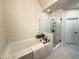 Relaxing bathroom featuring soaking tub, glass shower, white marble tile, and modern fixtures at 1411 Wisteria Wall Dr, Suwanee, GA 30024