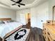 Bedroom with a tray ceiling, a ceiling fan, and a wood-frame bed at 1411 Wisteria Wall Dr, Suwanee, GA 30024