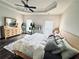Bright bedroom features a ceiling fan, wood dresser, and neutral tones at 1411 Wisteria Wall Dr, Suwanee, GA 30024