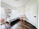 Cozy bedroom featuring light walls, wood floors, a charming desk, and ample natural light from two windows at 1411 Wisteria Wall Dr, Suwanee, GA 30024
