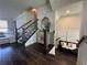 Beautiful entryway featuring dark wood floors, staircase, and decorated accent furniture at 1411 Wisteria Wall Dr, Suwanee, GA 30024