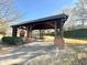 Community pavilion with a picnic table, brick pillars and fireplace on a sunny day at 1411 Wisteria Wall Dr, Suwanee, GA 30024