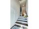 Elegant staircase with dark wood steps, white paneled walls, and stylish decor at 1411 Wisteria Wall Dr, Suwanee, GA 30024
