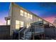 View of the back deck and fenced yard of this lovely townhome with lots of windows at dusk at 3180 Spicy Cedar Ln, Lithonia, GA 30038