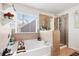 Bright bathroom featuring a soaking tub, glass shower, and neutral tile work at 3180 Spicy Cedar Ln, Lithonia, GA 30038