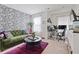 Cozy living room area featuring a stylish green sofa and adjacent work space at 3180 Spicy Cedar Ln, Lithonia, GA 30038