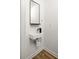 Stylish powder room featuring modern wall-mounted sink and arched mirror at 731 Hobart Se Ave, Atlanta, GA 30312